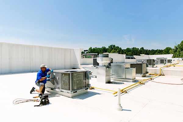 Tech on the roof top checking HVAC